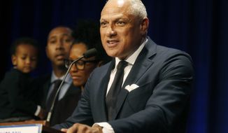 FILE - In this Nov. 27, 2018 file photo, Mississippi Democrat Mike Espy stands with family members as he talks to supporters in a crowded auditorium at the Mississippi Civil Rights Museum in Jackson, Miss., after losing the runoff election. On Tuesday, Nov. 12, 2019, Espy announced another run for U.S. Senate, setting up a 2020 rematch with Republican Cindy Hyde-Smith.  (AP Photo/Charles A. Smith, File)