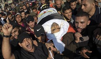Palestinians chant angry slogans as they carry the body of Islamic Jihad commander, Bahaa Abu el-Atta, who was killed with his wife by an Israeli missile strike hit his house early morning, during his funeral in Gaza City, Tuesday, Nov. 12, 2019. (AP Photo/Khalil Hamra)