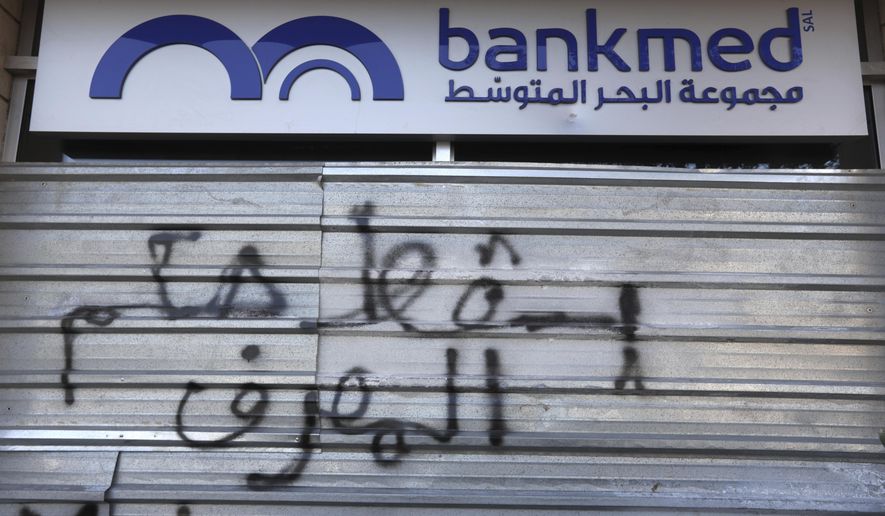A door of a closed bank is spray painted with a message in Arabic that reads, &amp;quot;Down with the rule of the banks,&amp;quot; in Beirut, Lebanon, Tuesday, Nov. 12, 2019. Lebanon&#x27;s banking association says banks will stay closed due to a strike by employees, as country&#x27;s financial crisis worsens. (AP Photo/Hassan Ammar)