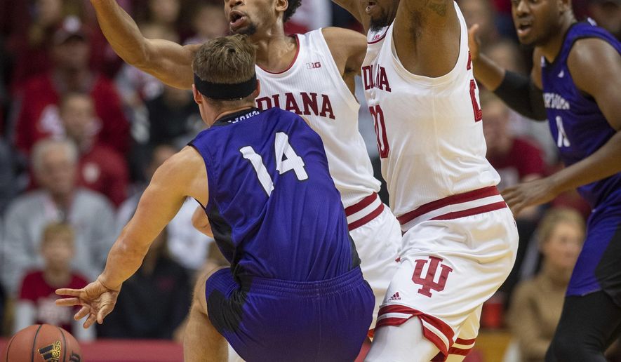 North Alabama&#39;s Payton Youngblood (14) is double-teamed by Indiana&#39;s Justin Smith (3), center, and De&#39;Ron Davis (20) during the first half of an NCAA college basketball game, Tuesday, Nov. 12, 2019, in Bloomington, Ind. (AP Photo/Doug McSchooler)