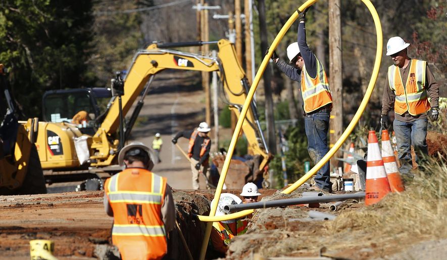 FILE - In this Oct. 18, 2019, file photo, Pacific Gas and Electric Company workmen bury utility lines in Paradise, Calif. California regulators are voting Wednesday, Nov. 13, on whether to open an investigation into pre-emptive power outages that blacked out large parts of the state for much of October as strong winds sparked fears of wildfires. PG&E officials insisted on the shut-offs to prevent wildfires but a parade of public officials complained the company botched its communications. (AP Photo/Rich Pedroncelli, File)
