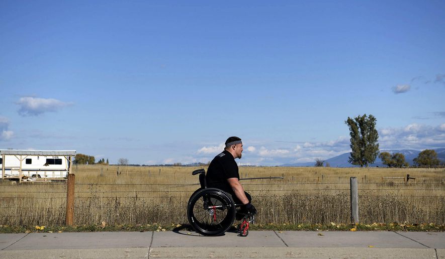 In this Aug. 7, 2019 photo, Thomas (Tomy) Parker, a 29-year-old Marine Corp veteran and triple amputee, trains and gets exercise near downtown Ronan, Mont. The Montana Marine who lost his legs to an IED in Afghanistan came home to a hero&#x27;s welcome and a house was built for him, but he lost it to addiction. Parker attended rehab, is being treated for PTSD and is now competing in wheelchair races. Parker often wears the same orange pants he was issued while serving time for possession of methamphetamine and heroin. (Tommy Martino/The Missoulian via AP)