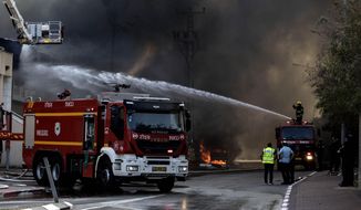 Firefighters deploy after a factory hit by a rocket caught fire in Sderot, southern Israel , Israel, Tuesday, Nov. 12m 2019. Israel has killed a senior Islamic Jihad commander in Gaza in a rare targeted killing that threatened to unleash a fierce round of cross-border violence with Palestinian militants. (AP Photo/Tsafrir Abayov)