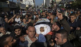 Palestinians chant angry slogans as they carry the body of Islamic Jihad commander, Bahaa Abu el-Atta, who was killed with his wife by an Israeli missile strike on their home, during his funeral in Gaza City, Tuesday, Nov. 12, 2019. (AP Photo/Khalil Hamra)