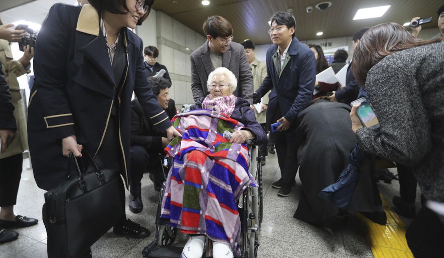 Former South Korean comfort woman Lee Ok-seon, center, leaves the Seoul Central District Court in Seoul, South Korea, Wednesday, Nov. 13, 2019. A Seoul court on Wednesday began hearing a long-awaited civil case filed against the Japanese government by South Korean women who were forced to work in Japan&#39;s World War II military brothels. (AP Photo/Ahn Young-joon)