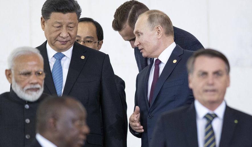 Russian President Vladimir Putin, top right, and China&#x27;s President Xi Jinping, top left, talk to each other as they and other leaders walk to attend the BRICS emerging economies at the Itamaraty palace in Brasilia, Brazil, Thursday, Nov. 14, 2019. (AP Photo/Pavel Golovkin, Pool)