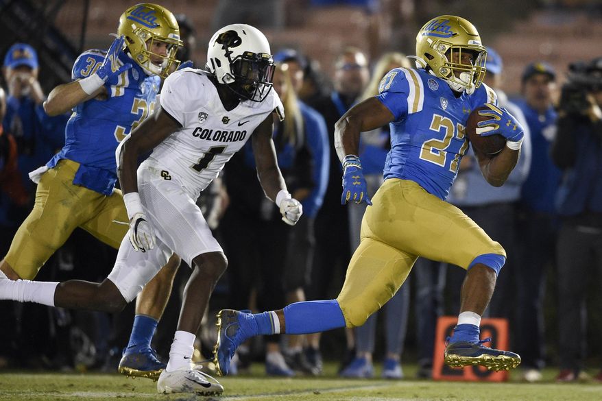 UCLA running back Joshua Kelley, right, runs for a touchdown past Colorado cornerback Delrick Abrams Jr., center, during the second half of an NCAA college football game as Ethan Fernea follows the play in Los Angeles, Saturday, Nov. 2, 2019. UCLA won 31-14. (AP Photo/Kelvin Kuo)