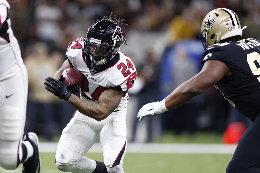 Atlanta Falcons running back Devonta Freeman (24) carries against New Orleans Saints defensive tackle Shy Tuttle (99) in the first half of an NFL football game in New Orleans, Sunday, Nov. 10, 2019. (AP Photo/Rusty Costanza)