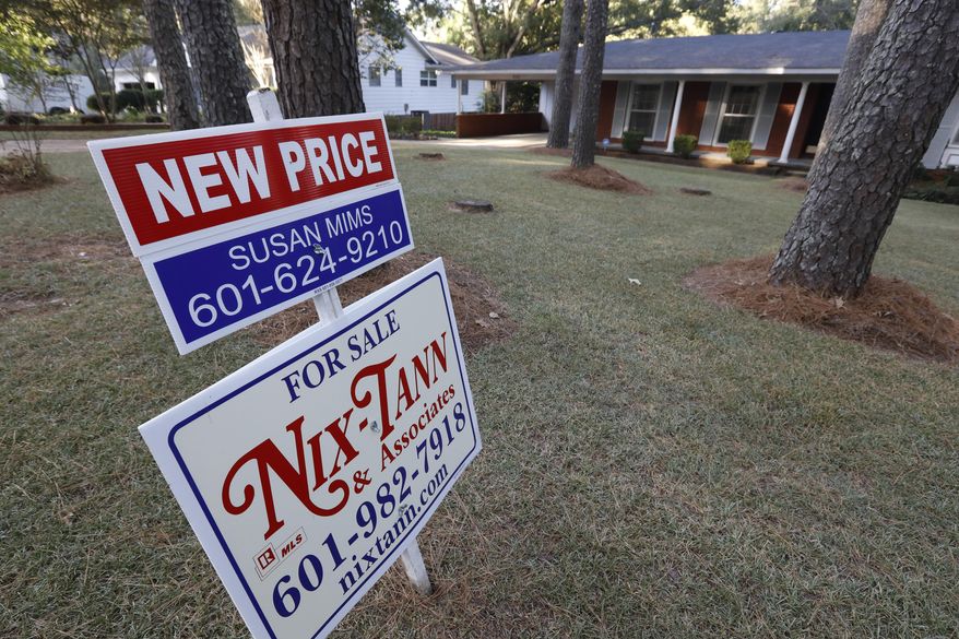 FILE - In this Sept. 25, 2019, file photo a sign indicates a new selling price for a house sits atop a realtor's sign in Jackson, Miss. On Thursday, Nov. 14, Freddie Mac reports on this week’s average U.S. mortgage rates. (AP Photo/Rogelio V. Solis, File)