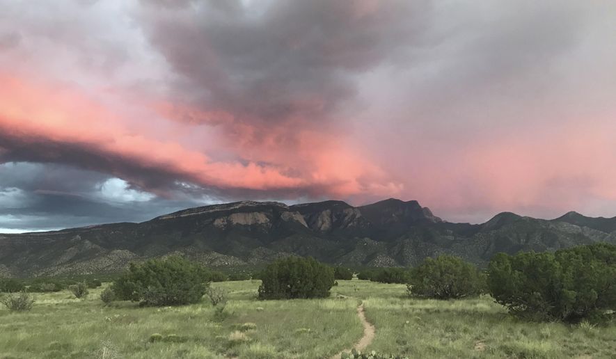 This Sept. 5, 2018 image shows a trail leading through national forest land toward the Sandia Mountains in Placitas, New Mexico. Officials say the outdoor recreation industry already brings billions of dollars to the state's coffers but there's room to grow. (AP Photo/Susan Montoya Bryan)