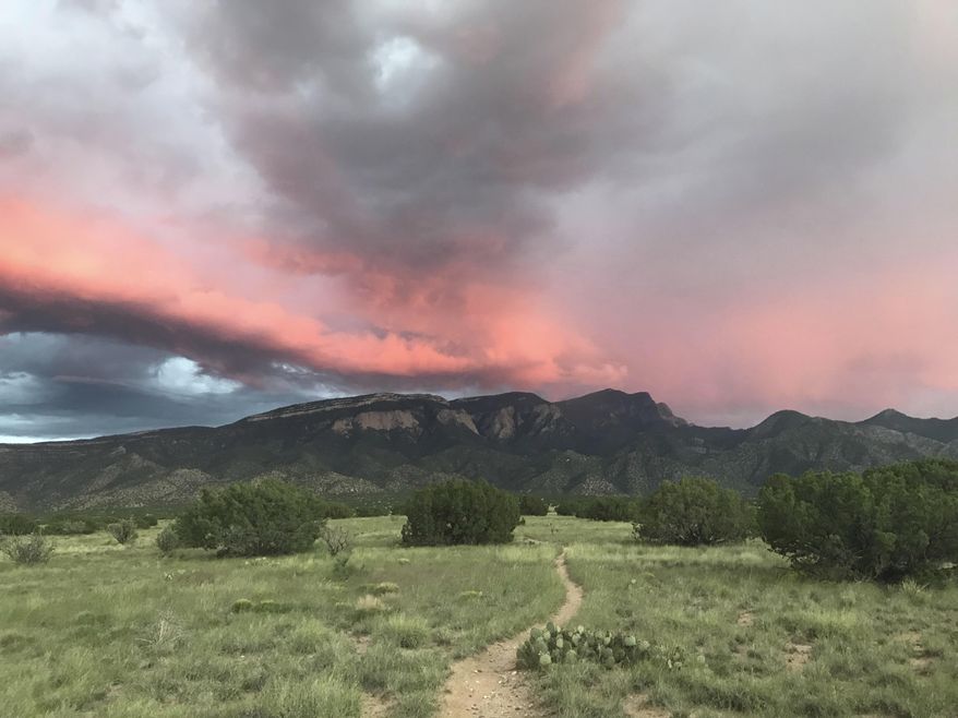This Sept. 5, 2018 image shows a trail leading through national forest land toward the Sandia Mountains in Placitas, New Mexico. Officials say the outdoor recreation industry already brings billions of dollars to the state's coffers but there's room to grow. (AP Photo/Susan Montoya Bryan)