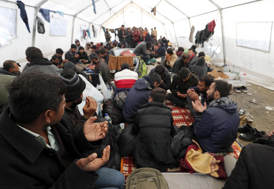 Migrants pray in the Vucjak refugee camp outside Bihac, northwestern Bosnia, Friday, Nov. 15, 2019. The European Union’s top migration official has joined the calls for the closure of a migrant camp in Bosnia set up on a former landfill. The EU has given Bosnia over 36 million euros ($40 million) in aid. But conditions at Vucjak are so bad that the EU’s migration commissioner says that “no EU financial support can, or will be, provided for it.” (AP Photo/Darko Vojinovic)