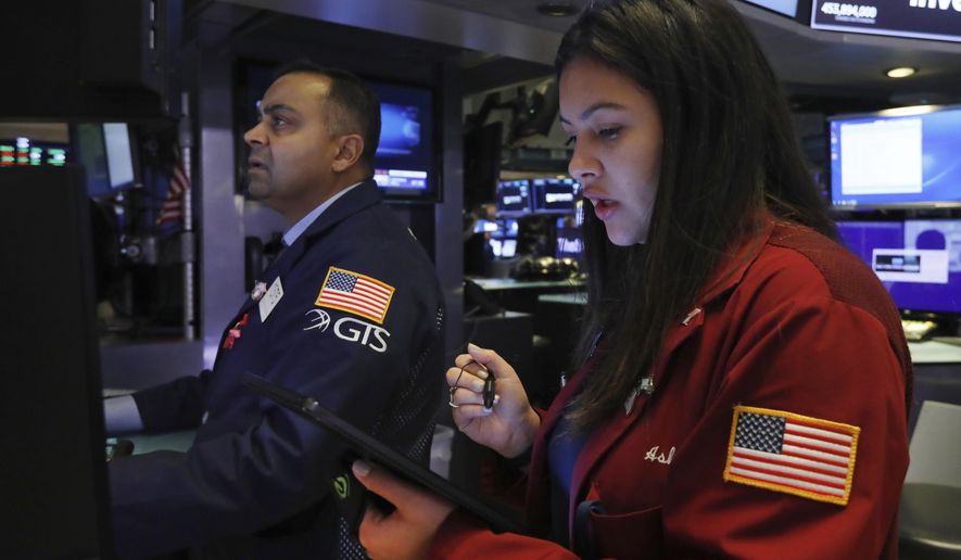 Specialist Dilip Patel, left, and trader Ashley Lara work on the floor of the New York Stock Exchange, Friday, Nov. 15, 2019. Stocks are opening broadly higher on Wall Street as hopes continued to grow that the U.S. and China were moving closer to a deal on trade. (AP Photo/Richard Drew)