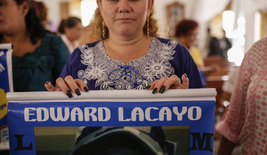 Mothers and relatives of jailed anti-government demonstrators holds signs with images of their imprisoned family, at the San Miguel Arcangel Church in Masaya, Nicaragua, Thursday, Nov. 14, 2019. The group have started a hunger strike to demand the freedom of their relatives, jailed for protesting against the government of President Daniel Ortega. (AP Photo/Alfredo Zuniga)