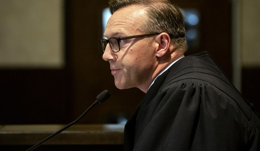 FILE - In this Aug. 26, 2019 file photo, Judge Thad Balkman reads a summary of his decision in the opioid trial at the Cleveland County Courthouse in Norman, Okla. Judge Balkman reduces amount Johnson & Johnson must pay state to help clean up opioid crisis by $107 million to $465 million on Friday Nov. 15, 2019. (Chris Landsberger/The Oklahoman via AP, Pool)