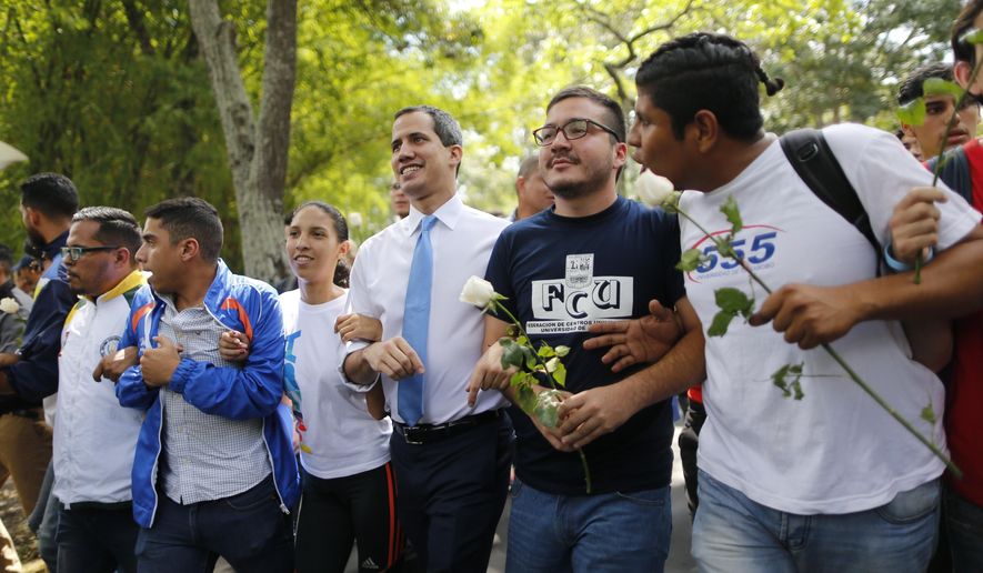 Venezuelan opposition leader, and self-proclaimed interim president of Venezuela, Juan Guaido, center, walks with students at the Central University of Venezuela after a meeting with them in Caracas, Venezuela, Thursday, Nov. 14, 2019. Guaido is calling people across the crisis-torn nation to flood the streets for protests nearly a year since launching an urgent campaign to push President Nicolás Maduro from power. (AP Photo/Ariana Cubillos)