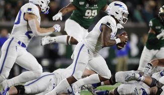 Air Force quarterback Donald Hammond III, front, runs for a short gain with Colorado State defensive lineman Ellison Hubbard in pursuit in the first half of an NCAA football game Saturday, Nov. 16, 2019 in Fort Collins, Colo. (AP Photo/David Zalubowski)