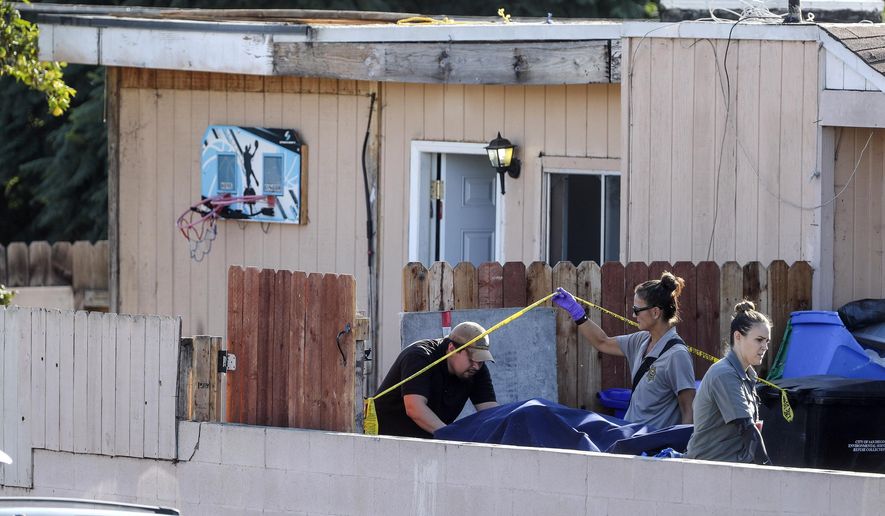 A body is carried out on a gurney at the home where two adults and three children died from gunshot wounds during a domestic shooting in the Paradise Hills area in San Diego, Calif., Saturday, Nov. 16, 2019. A husband and wife and three of their young children died Saturday morning at the family's San Diego home in what police believe was a murder-suicide sparked by a bitter divorce. One son is in critical condition. (Hayne Palmour IV/The San Diego Union-Tribune via AP)