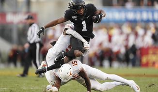 Iowa State wide receiver Tarique Milton (1) is tackled by Texas defenders D&#x27;Shawn Jamison, left, and Chris Brown after catching a pass during the first half of an NCAA college football game, Saturday, Nov. 16, 2019, in Ames, Iowa. (AP Photo/Charlie Neibergall)