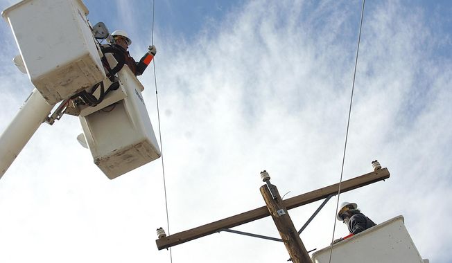 -Socorro Electric Cooperative linemen Juan Romero, left, and Henry Rosas work on a line just south of Socorro on Thursday March 20, 2008. (Adolphe Pierre-Louis/The Albuquerque Journal via AP)