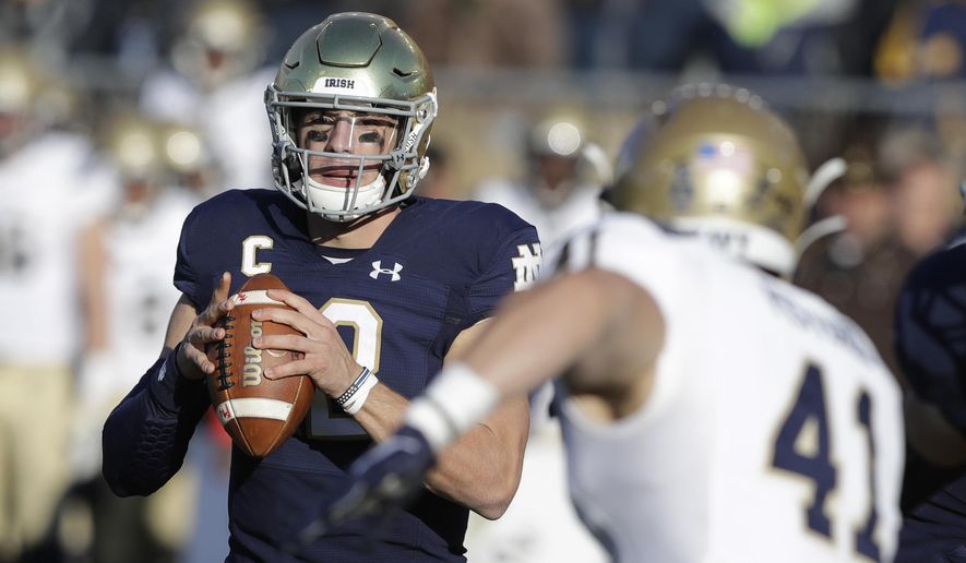 Notre Dame quarterback Ian Book (12) throws against Navy linebacker Tyler Pistorio (41) during the first half of an NCAA college football game, Saturday, Nov. 16, 2019, in South Bend, Ind. (AP Photo/Darron Cummings)
