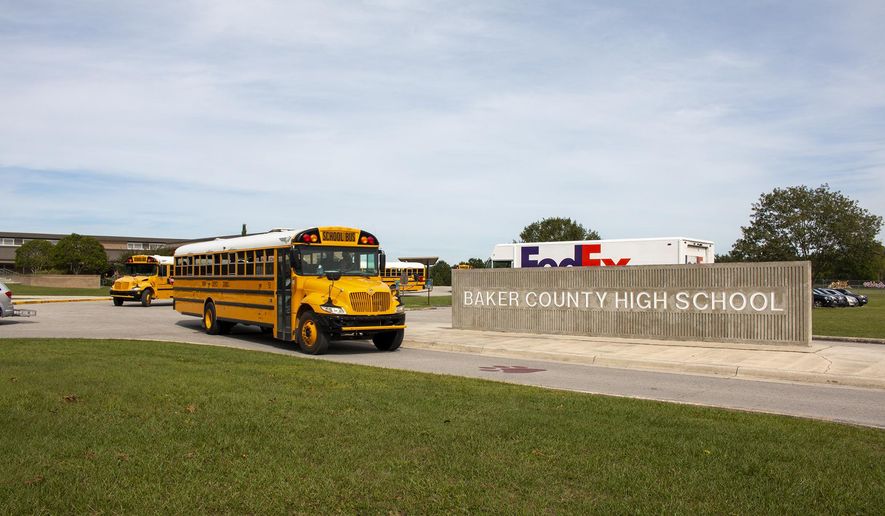 In this Oct. 17, 2019 photo, buses depart from Baker County High School in Glen St. Mary, Fla. Unease spread across Baker County when authorities arrested a 15-year-old who they say planned a massacre at the county's only high school. Anger grew when a judge dismissed second-degree felony charges against the boy.(AP Photo/Bobby Caina Calvan)