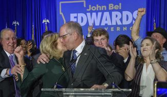 Louisiana Gov. John Bel Edwards celebrates with his wife Donna Edwards as he arrives to address supporters at his election night watch party in Baton Rouge, La., Saturday, Nov. 16, 2019. (AP Photo/Matthew Hinton)
