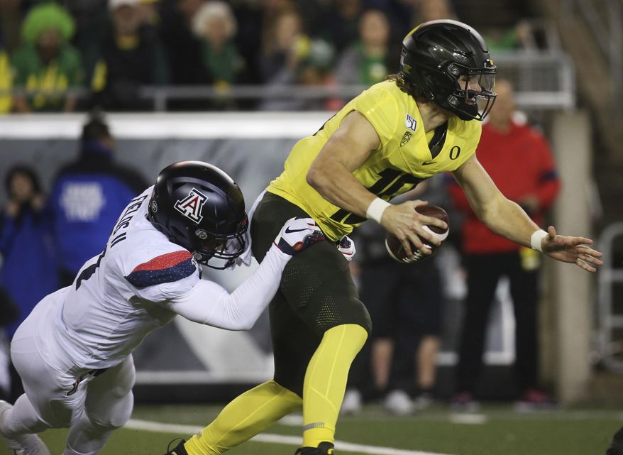 Arizona's Tony Fields II, left, sacks Oregon quarterback Justin Herbert during the second quarter of an NCAA college football game Saturday, Nov. 16, 2019, in Eugene, Ore. (AP Photo/Chris Pietsch)