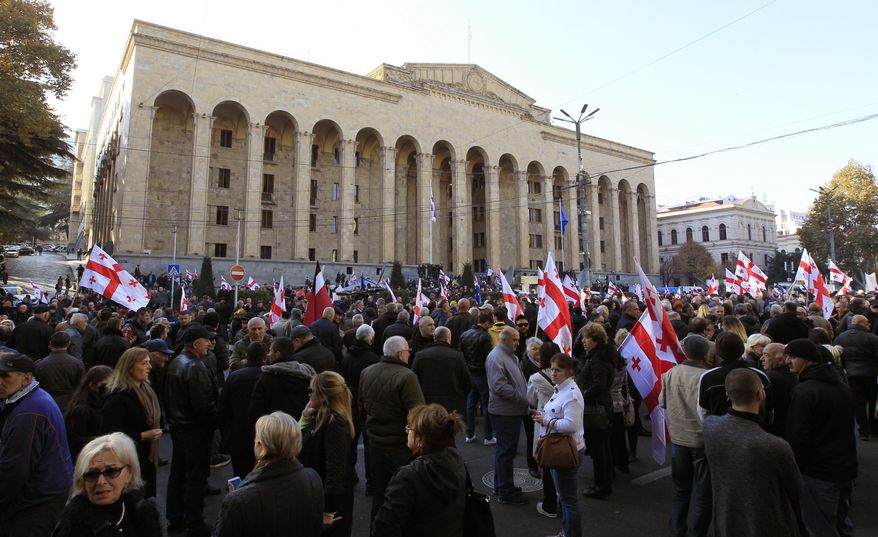 Demonstrators gather at the Georgian parliament building to protest against government failures to pass election-reform constitutional measures, in Tbilisi, Georgia, Sunday, Nov. 17, 2019. Some hundreds of demonstrators gathered outside the parliament building to protest after the government backed down on a promise to reform the election system that supports the ruling party. (AP Photo/Shakh Aivazov)