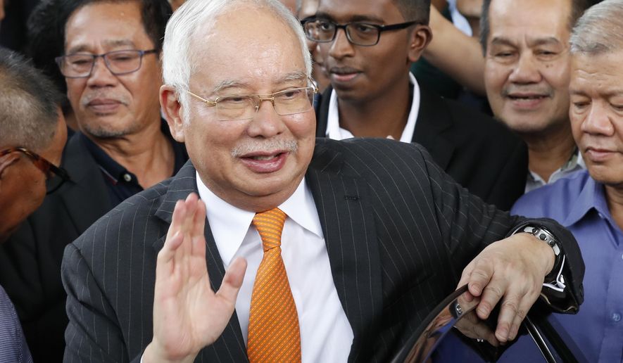 FILE - In this Nov. 11, 2019, file photo, former Malaysian Prime Minister Najib Razak waves as he leaves Kuala Lumpur High Court in Kuala Lumpur, Malaysia. Najib’s third corruption trial has started Monday, Nov 18, 2019, with prosecutors saying he tampered with a government audit on the 1MDB state investment fund in a bid to avoid civil and criminal proceedings. (AP Photo/Vincent Thian, File)