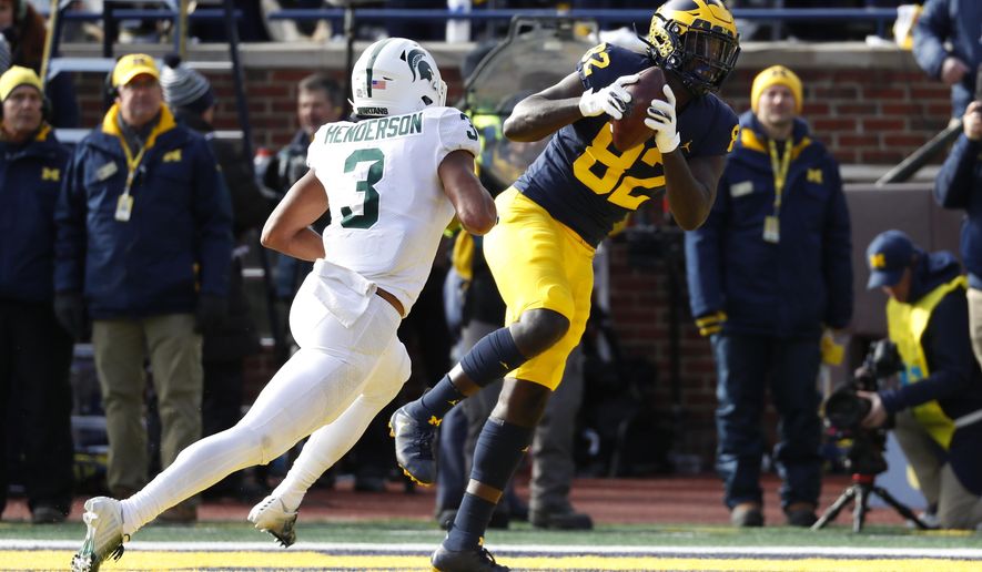 Michigan tight end Nick Eubanks (82) catches a 5-yard touchdown pass as Michigan State safety Xavier Henderson (3) defends in the first half of an NCAA college football game in Ann Arbor, Mich., Saturday, Nov. 16, 2019. (AP Photo/Paul Sancya)