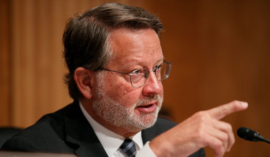 Sen. Gary Peters, Michigan Democrat, is accused of exploiting a legal gray area to improperly coordinate with VoteVets, a progressive veterans advocacy group. His campaign website and an ad the group bought used the same photos and videos. (Associated Press)