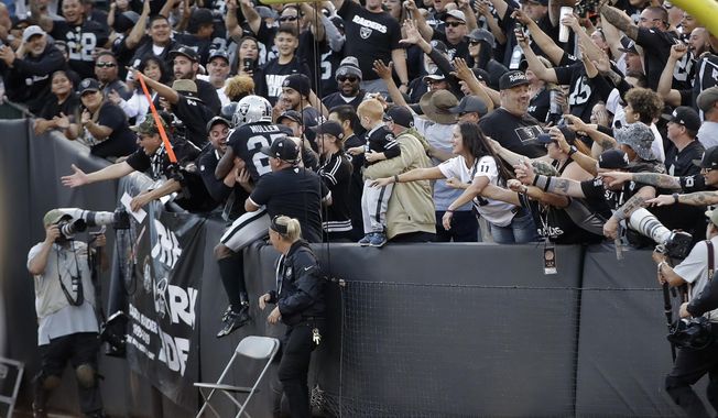 Oakland Raiders cornerback Trayvon Mullen is greeted by fans after making an interception late in the second half of an NFL football game against the Cincinnati Bengals in Oakland, Calif., Sunday, Nov. 17, 2019. Oakland won the game 17-10. (AP Photo/Ben Margot)
