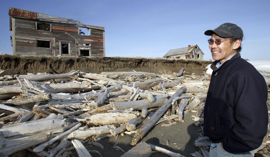 FILE - In this May 27, 2006, file photo, Simon Bekoalok stands where the eroding land was when he was a child growning up in the now abandoned village of Shaktoolik, Alaska. Grants to turn dredged sediment into Texas marshland and to protect a small Alaska community from the Bering Sea are among 44 announced Monday, Nov. 18, 2019. (AP Photo/Al Grillo, File)