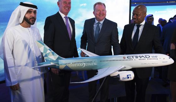 Etihad COO Mohammad al-Bulooki, left, Etihad CEO Tony Douglas, second left, Boeing Commercial Airplanes president and CEO Stanley A. Deal, third left, and Boeing Global Services President and CEO Ted Colbert, right, pose in front of a Boeing 787 Dreamliner model at the Dubai Airshow in Dubai, United Arab Emirates, Monday, Nov. 18, 2019. Abu Dhabi&#39;s flagship carrier Etihad said Monday it had partnered with Boeing Co. to launch what they say will be one of the world&#39;s most fuel-efficient long haul airplanes as the company seeks to save costs on fuel and position itself as a more environmentally-conscious choice for travelers. (AP Photo/Jon Gambrell)