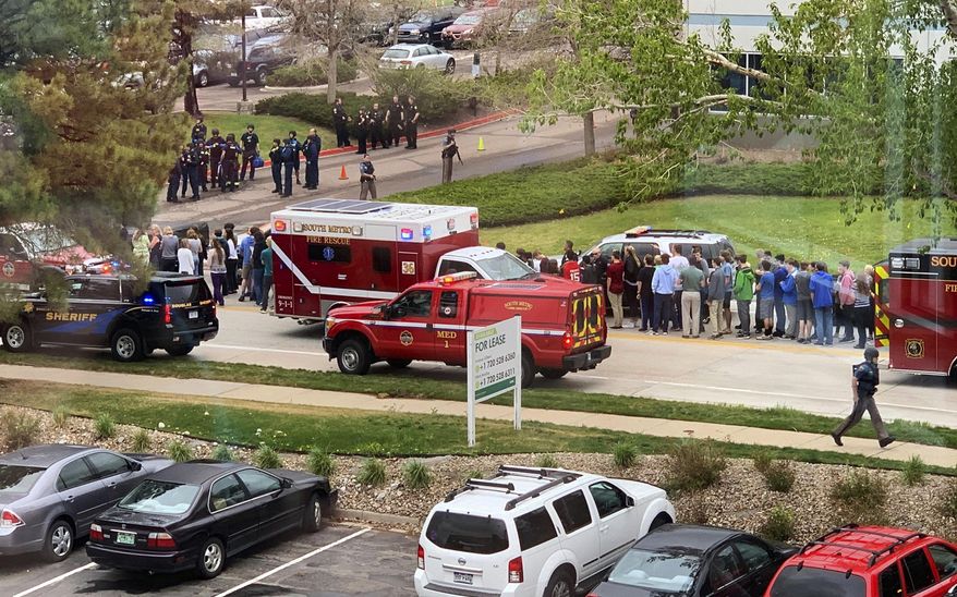 FILE - In this May 7, 2019 file photo, police officers and students are seen outside STEM School Highlands Ranch, a charter middle school in the Denver suburb of Highlands Ranch, Colo., after a shooting. A judge is scheduled to hear arguments starting Monday, Nov. 18, 2019, on whether prosecutors have enough evidence to take the case against one of the two teen suspects to trial, and whether 16-year-old Alec McKinney should be tried as an adult. (Courtney Harper via AP, File)