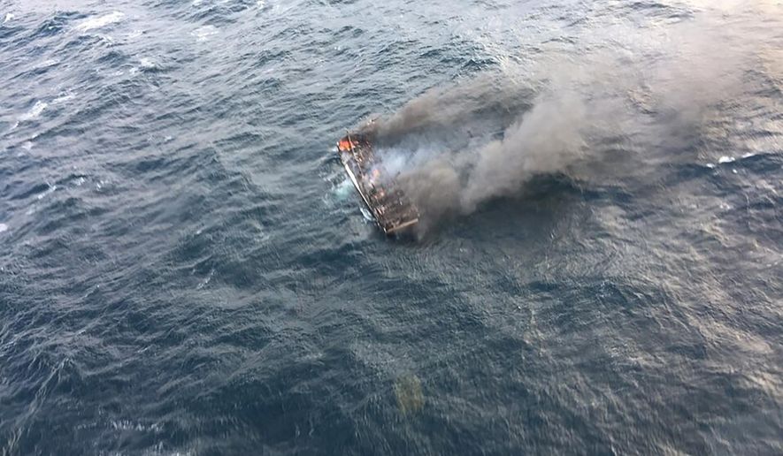 This photo provided by the Korea Jeju Coast Guard, shows a fishing boat in a smoke in waters near the southern island of Jeju, in South Korea, Tuesday, Nov. 19, 2019. South Korea's coast guard says about a dozen people are missing from a fishing boat that caught fire in waters near the southern island of Jeju. (Korea Jeju Coast Guard via AP)