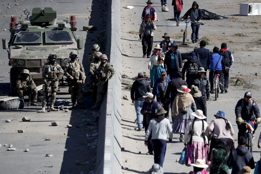 Soldiers guard the Senkata fuel plant in El Alto, on the outskirts of La Paz, Bolivia, Wednesday, Nov. 20, 2019. Security forces on Tuesday escorted gasoline tankers from the plant, that had been blockaded for five days by supporters of former President Evo Morales, and at least three people were reported killed while the operation was underway. (AP Photo/Natacha Pisarenko)