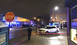 Chicago Police investigate the scene where an officer was shot by a suspected bank robber in the 4300 block of West Irving Park Road, Tuesday night, Nov. 19, 2019. A 15-year-old boy was also wounded in the shooting, while the suspect was shot and killed. (Sam Charles/Chicago Sun-Times via AP)