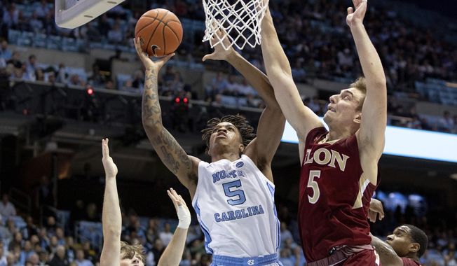North Carolina&#x27;s Armando Bacot, left, attempts a shot as Elon&#x27;s Federico Poser, right, defends during the first half of an NCAA college basketball game in Chapel Hill, N.C., Wednesday, Nov. 20, 2019. (AP Photo/Ben McKeown)