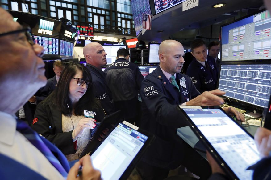 Specialist Mario Picone, right, works with traders at his post on the floor of the New York Stock Exchange, Wednesday, Nov. 20, 2019. Stocks are opening slightly lower on Wall Street led by declines in technology and communications companies. (AP Photo/Richard Drew)
