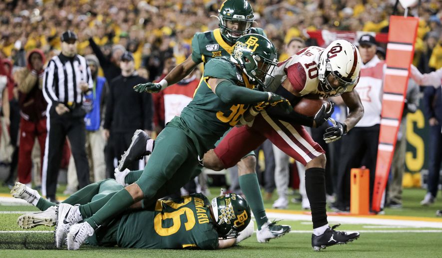 Oklahoma wide receiver Theo Wease (10) scores a 19-yard touchdown as Baylor linebacker Jordan Williams (38) defends during the second half of an NCAA college football game in Waco, Texas, Saturday, Nov. 16, 2019. Oklahoma won 34-31. (AP Photo/Ray Carlin)