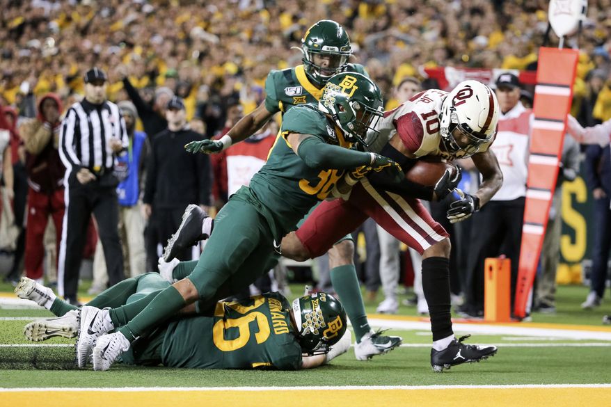 Oklahoma wide receiver Theo Wease (10) scores a 19-yard touchdown as Baylor linebacker Jordan Williams (38) defends during the second half of an NCAA college football game in Waco, Texas, Saturday, Nov. 16, 2019. Oklahoma won 34-31. (AP Photo/Ray Carlin)