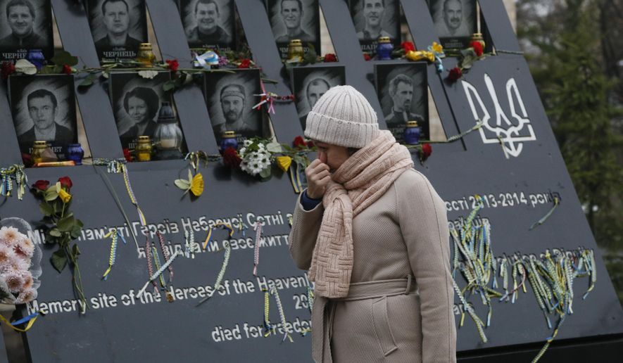 A woman pays her respect at a memorial dedicated to people died in clashes with security forces at the Independent Square (Maidan) in Kyiv, Ukraine, Thursday, Nov. 21, 2019 to mark the sixth anniversary of the beginning of the protests. People gather to commemorate the Maidan protest movement and the events which took place in late Feb. 2014 that led to the departure of former Ukrainian President Victor Yanukovich and the formation of a new government. (AP Photo/Efrem Lukatsky)