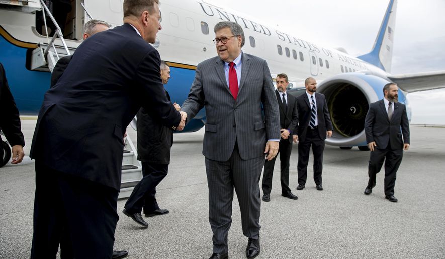 Attorney General William Barr greets members of the Cleveland FBI field office's SWAT team before boarding an aircraft at Burke Lakefront Airport, Thursday, Nov. 21, 2019, in Cleveland. Barr participated in a roundtable discussion with members of local, state and federal law enforcement, and is en route to Montana, where he is scheduled Friday to address missing and murdered indigenous persons. (AP Photo/Patrick Semansky)