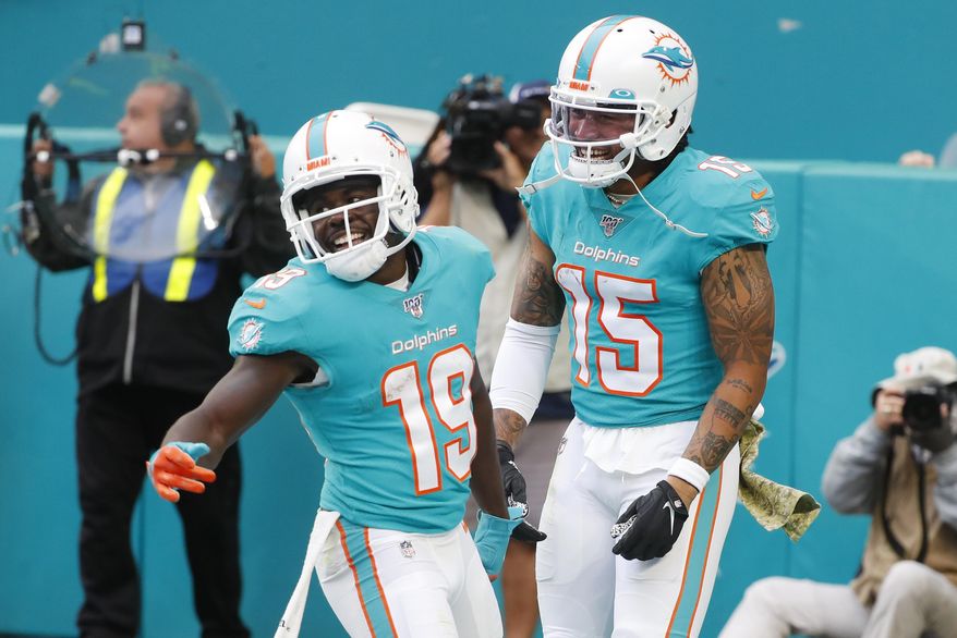 Miami Dolphins wide receiver Albert Wilson (15), congratulates wide receiver Jakeem Grant (19), after Grant scored a touchdown during the second half at an NFL football game against the Buffalo Bills, Sunday, Nov. 17, 2019, in Miami Gardens, Fla. (AP Photo/Wilfredo Lee)
