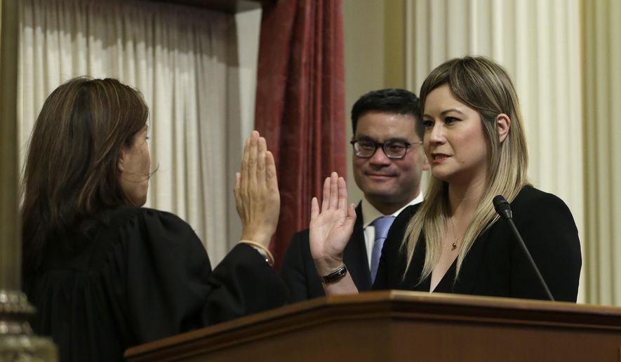 FILE — In this June 25, 2018 file photo Republican Ling Ling Chang, right, is sworn in to the California Senate by California Supreme Court Chief Justice Tani Cantil-Sakauye, as Chang's husband, Andrew Wong looks on in Sacramento, Calif. Chang announced Thursday, Nov. 21, 2019, that she will introduce legislation in January to make it a crime to send unwanted nude photos to people online or in text messages. (AP Photo/Rich Pedroncelli, File)