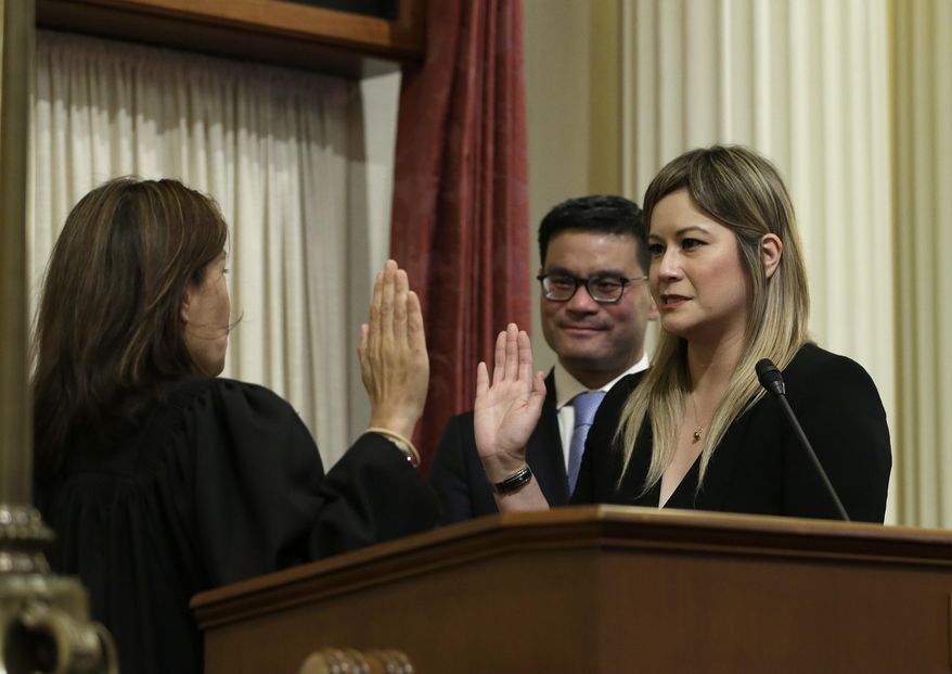 FILE — In this June 25, 2018 file photo Republican Ling Ling Chang, right, is sworn in to the California Senate by California Supreme Court Chief Justice Tani Cantil-Sakauye, as Chang's husband, Andrew Wong looks on in Sacramento, Calif. Chang announced Thursday, Nov. 21, 2019, that she will introduce legislation in January to make it a crime to send unwanted nude photos to people online or in text messages. (AP Photo/Rich Pedroncelli, File)