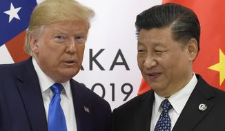 In this June 29, 2019, photo, U.S. President Donald Trump poses for a photo with Chinese President Xi Jinping during a meeting on the sidelines of the G-20 summit in Osaka, western Japan. (AP Photo/Susan Walsh) **FILE**