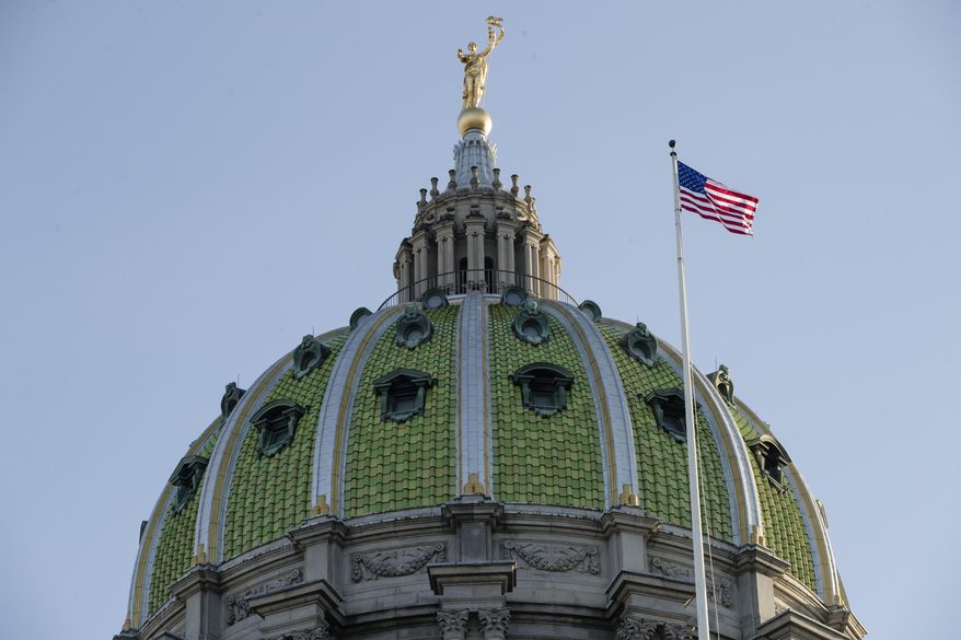 FILE- In this Jan. 15, 2019, file photo an America flag flies at the Pennsylvania Capitol building in Harrisburg, Pa. Pennsylvania lawmakers are expected to make the final vote on a bill to provide more time to file charges or lawsuits over cases of sexual abuse after a debate roiled by last year’s grand jury report into child molestation by Roman Catholic priests. A state House Republican spokesman says the chamber will vote Thursday, Nov. 21, 2019, likely sending it to Democratic Gov. Tom Wolf. (AP Photo/Matt Rourke, File)